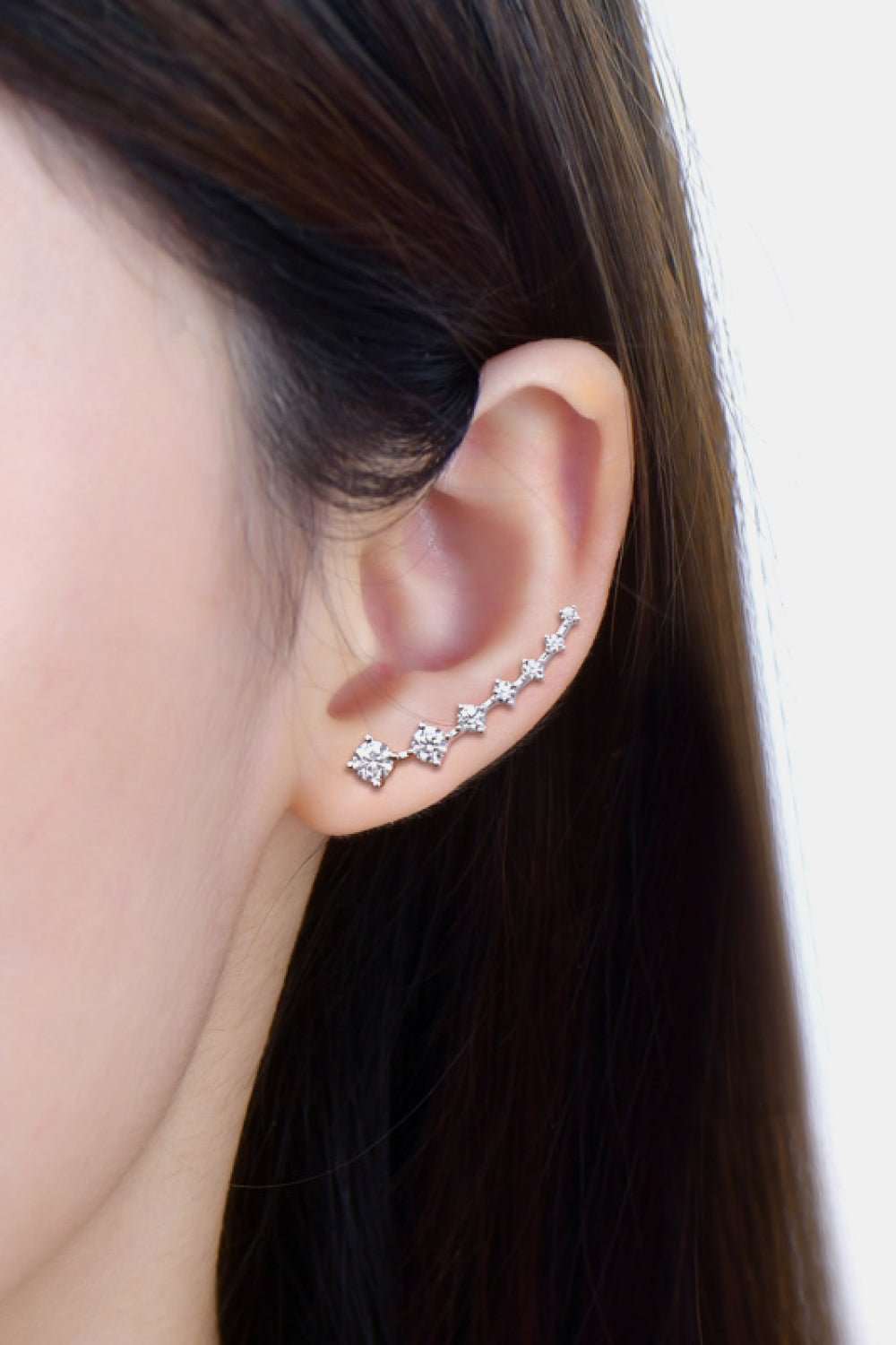 Elegant crystal flower ear climbers on dark hair - sparkling silver-tone earrings with delicate floral design, stylish jewelry accessory.