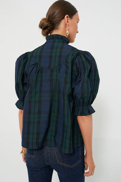 a woman wearing a black and green plaid shirt