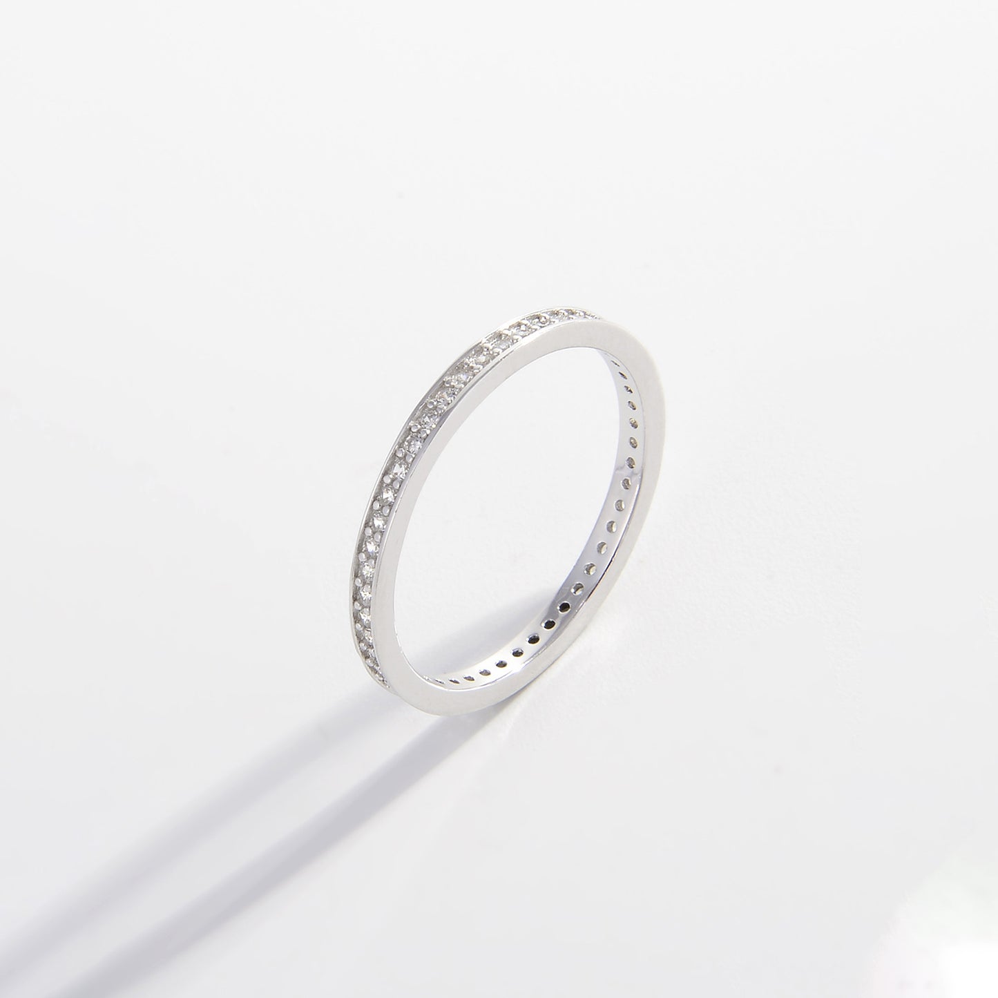 a white gold ring with small diamonds on a white background