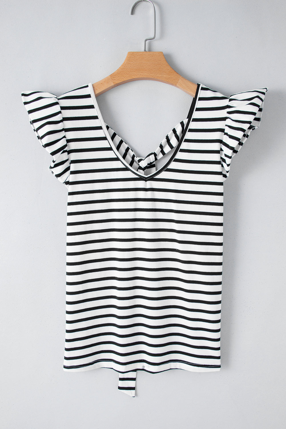 a black and white striped shirt hanging on a wooden hanger