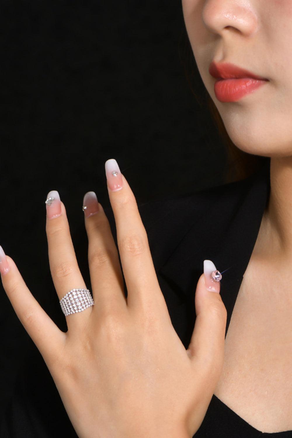 Elegant diamond ring on female's hand against dark background