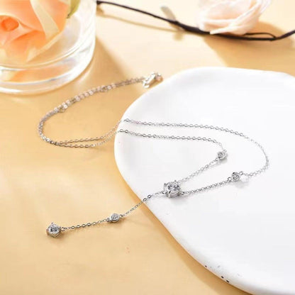 Elegant sterling silver necklace with 1.5 carat moissanite stones, set in a delicate chain design, displayed with a white rose accent.