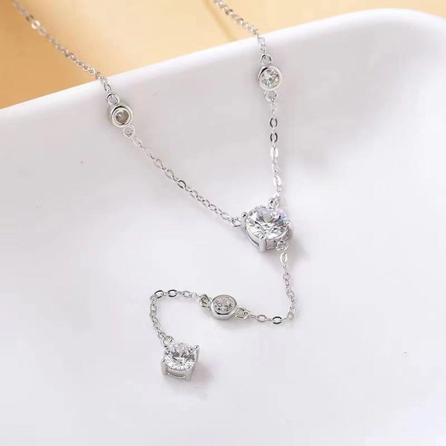 Elegant moissanite necklace with sterling silver chain and accents, showcasing a shimmering moissanite gemstone pendant.