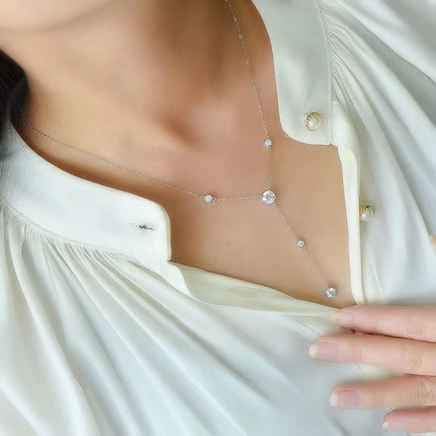 Sparkling sterling silver necklace with 1.5 carat moissanite stones, elegantly displayed against a soft, white fabric backdrop.