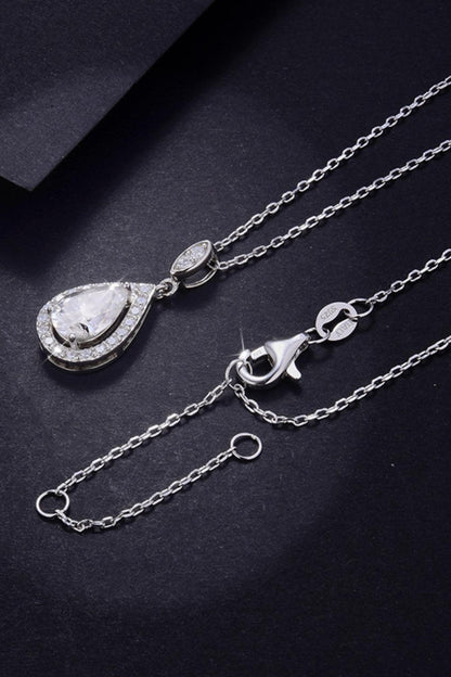 Elegant silver teardrop pendant necklace with sparkling crystals on a delicate chain, showcased against a dark background.