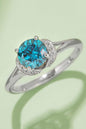 Dazzling blue moissanite solitaire ring, sparkling diamond accents, sleek sterling silver band, elegant jewelry piece.