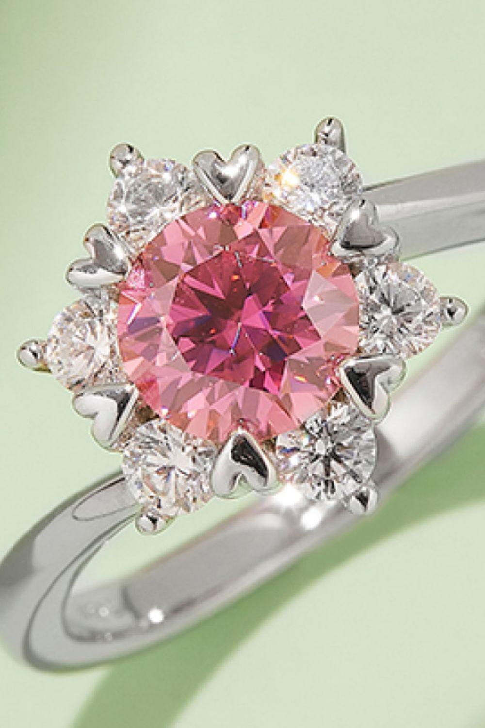 Elegant moissanite and sterling silver cluster ring with a captivating pink center gemstone.