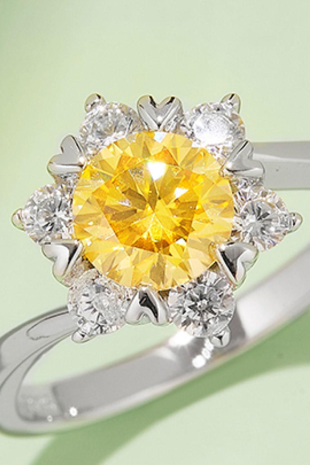 Elegant sterling silver ring featuring a vibrant yellow moissanite center gem surrounded by sparkling white moissanite accents.