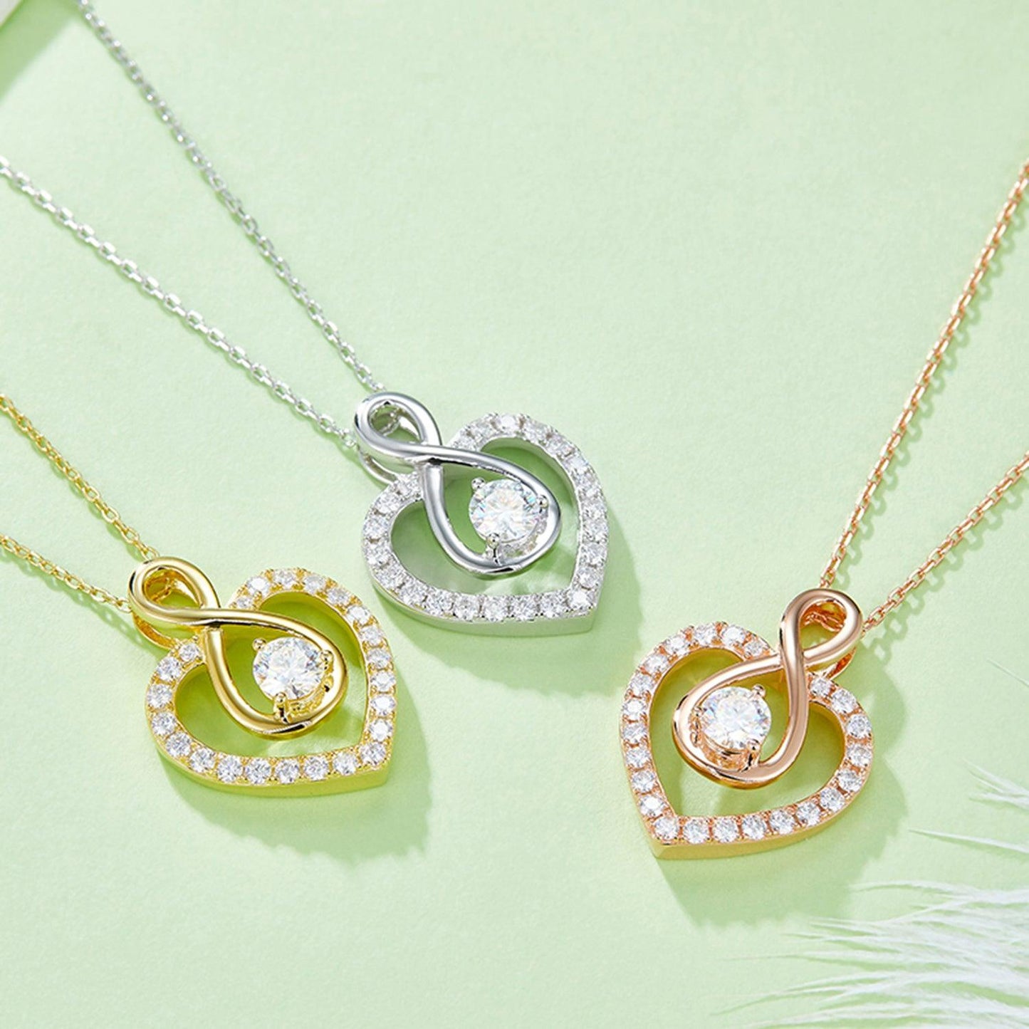 Elegant heart-shaped 1 carat Moissanite necklaces in 925 sterling silver set on a light green background. The necklaces feature a dazzling diamond-encrusted design, showcasing the exquisite craftsmanship and attention to detail of these stunning jewelry pieces.