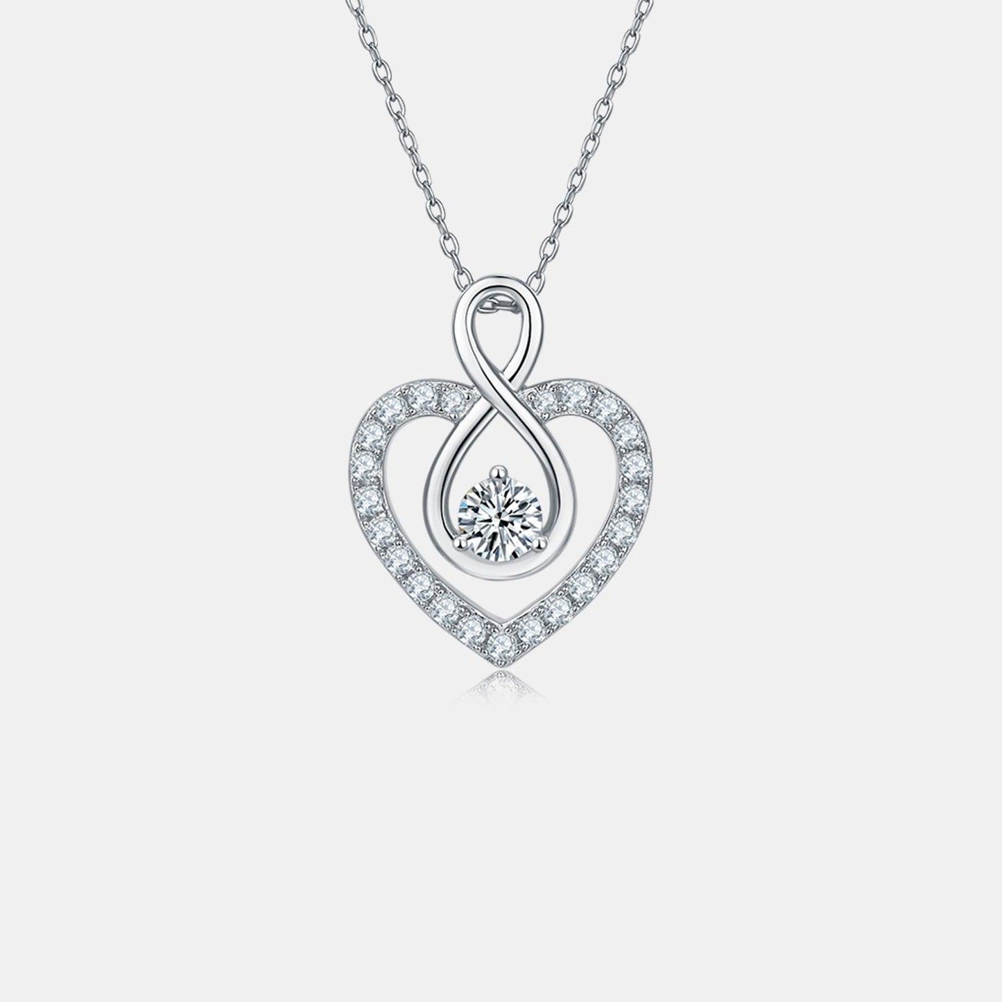 Elegant sterling silver heart-shaped necklace with 1 carat moissanite center stone and sparkling cubic zirconia accents.