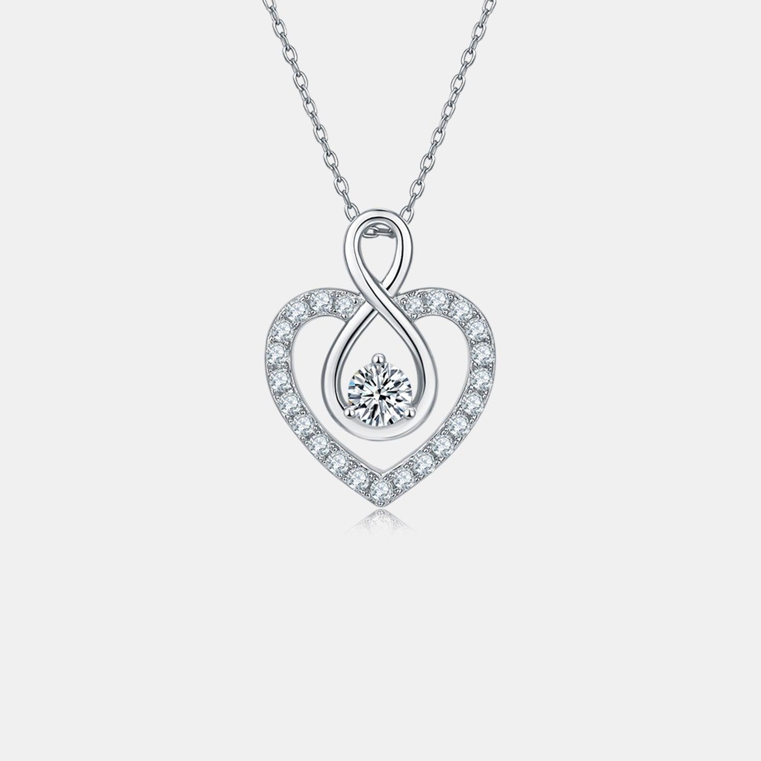 Elegant sterling silver heart-shaped necklace with 1 carat moissanite center stone and sparkling cubic zirconia accents.