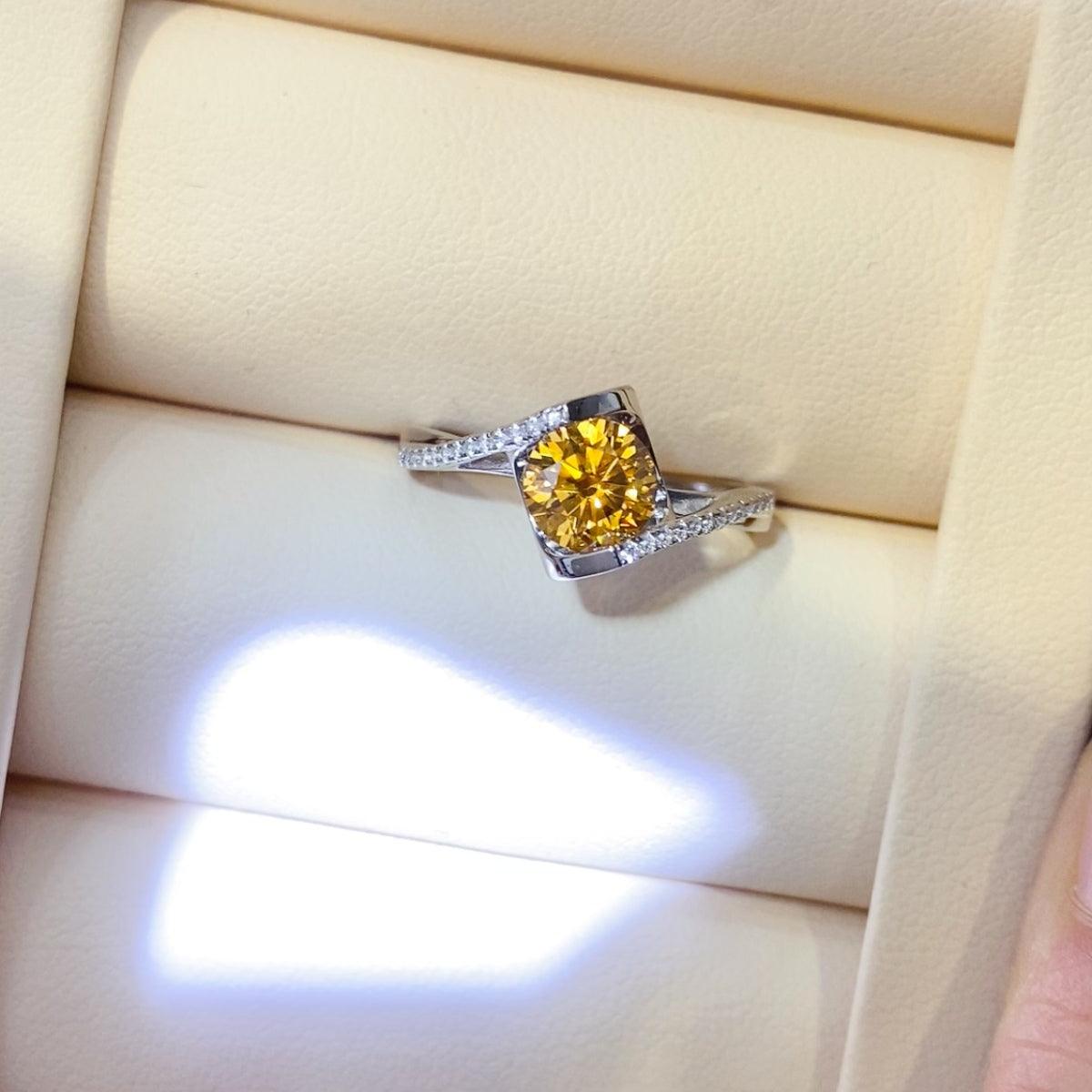 Elegant yellow gemstone ring with sparkling diamond accents on a silver band against a neutral background