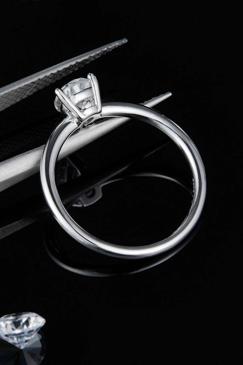 Elegant moissanite solitaire ring set in sleek sterling silver, showcased against a dark background