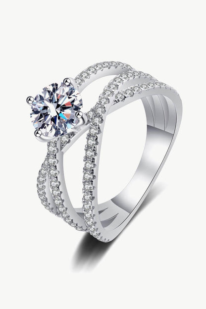 Elegant 1 Carat Moissanite Crisscross Ring showcased on a plain background. The ring features a shimmering diamond-like center stone surrounded by a dazzling band of smaller crystals, creating a luxurious and eye-catching design.