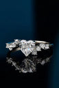 Elegant heart-shaped moissanite ring with sparkling side stones on dark background