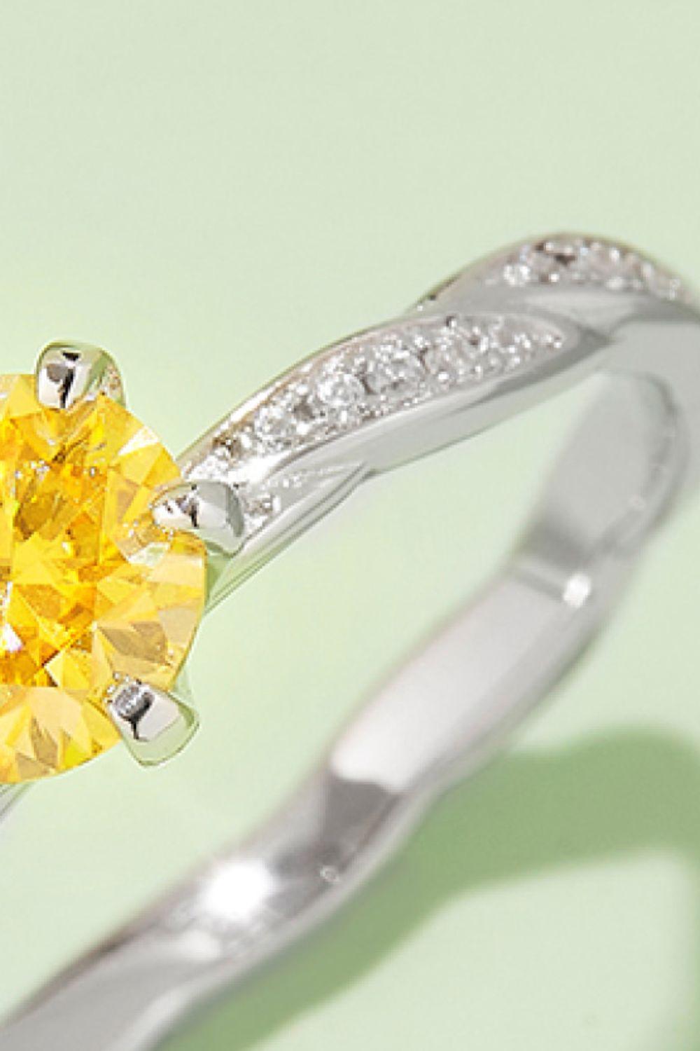 Shimmering sterling silver ring with a captivating yellow moissanite center stone and sparkling diamond accents.