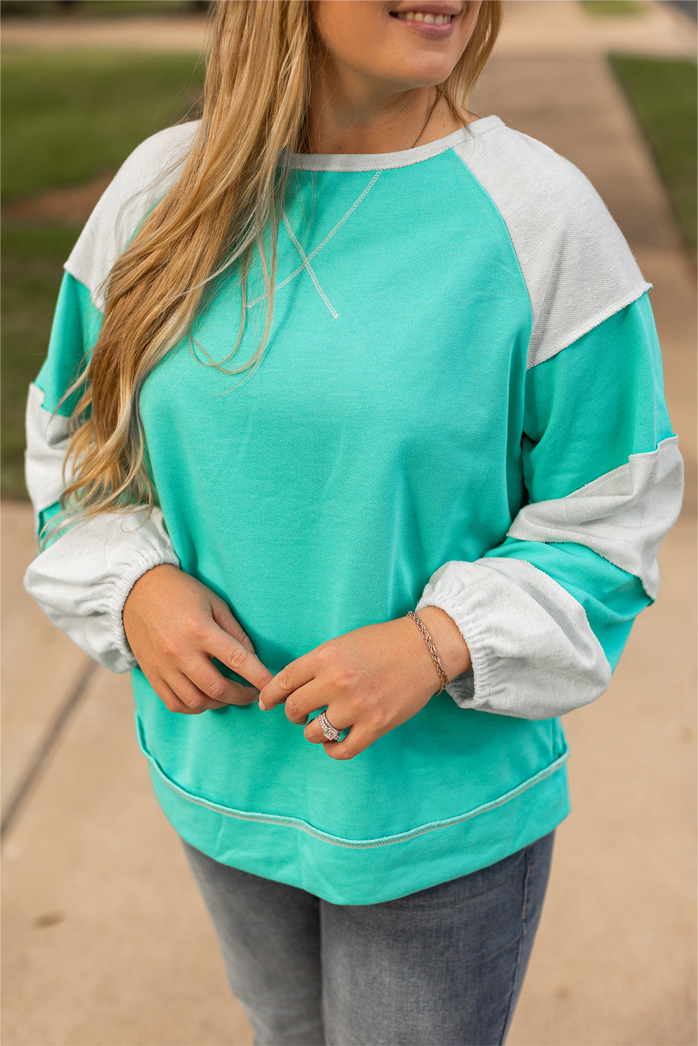 a woman wearing a green and white sweatshirt