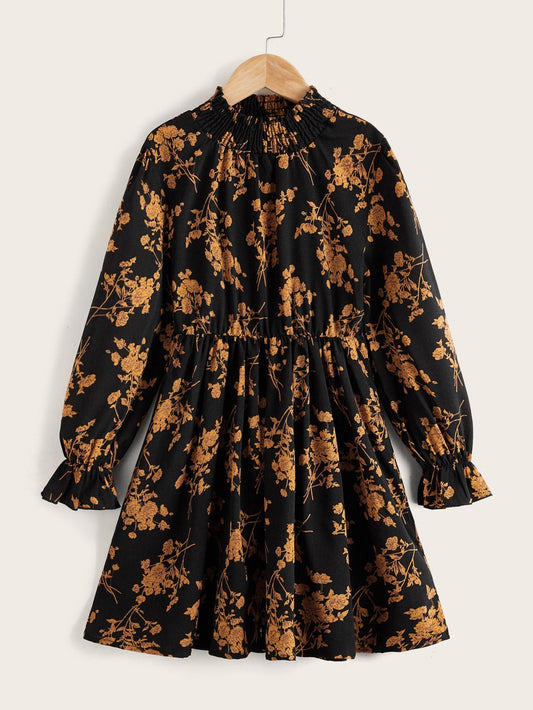 a black and gold floral dress hanging on a hanger