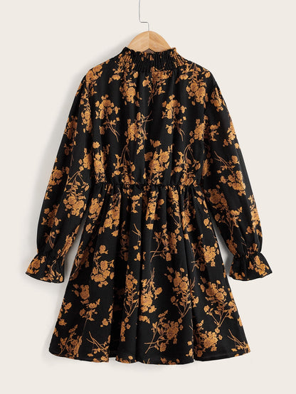 a black and gold floral dress hanging on a hanger