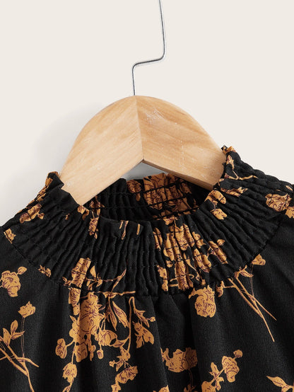 a black and gold dress with a wooden hanger