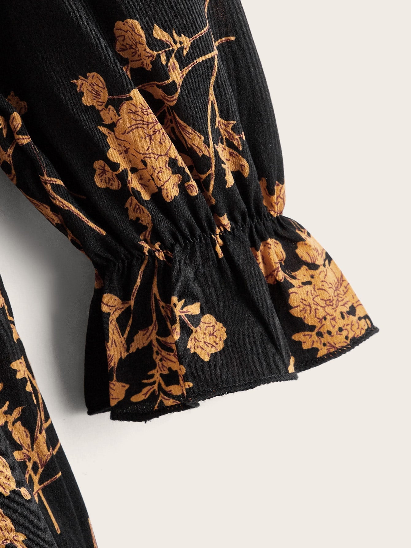 a close up of a black and gold floral print scarf