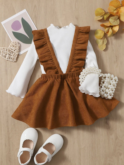 a baby girl's outfit and shoes on a table