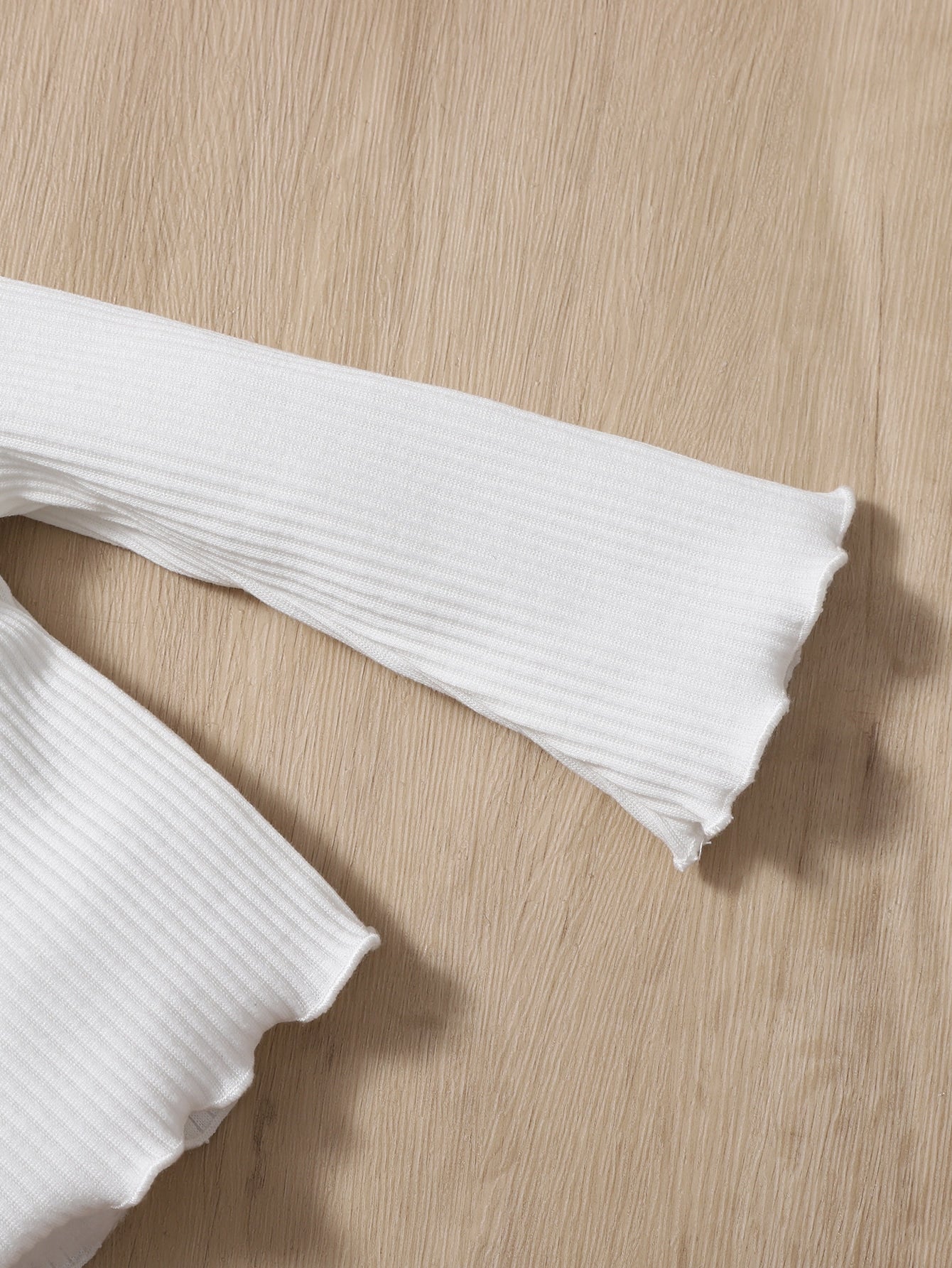 a pair of white gloves laying on top of a wooden table