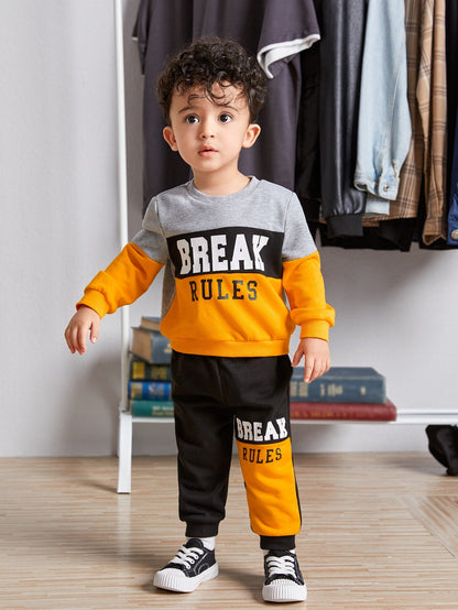 a little boy standing in front of a rack of clothes