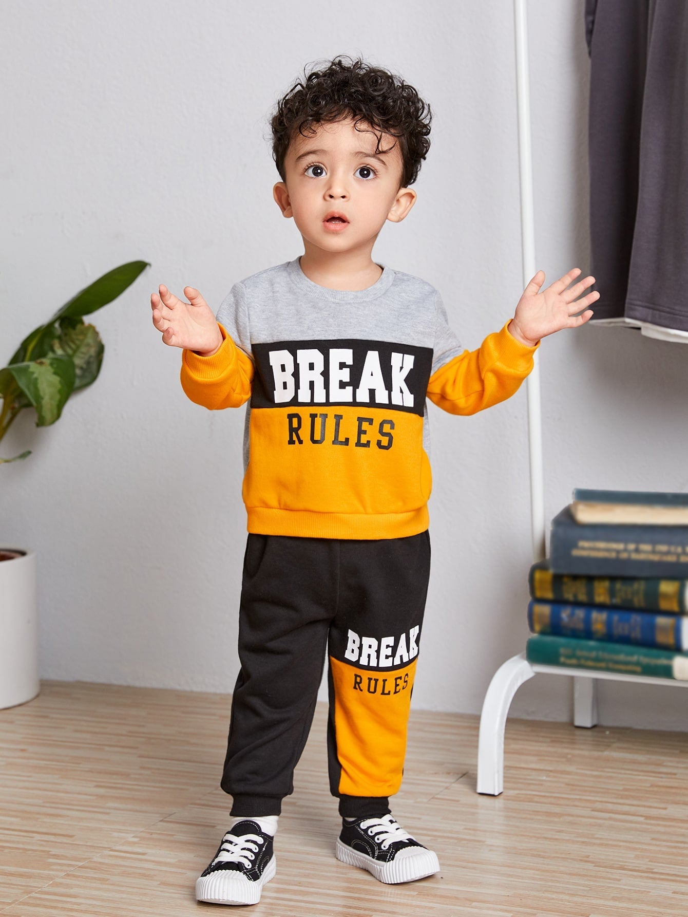 a little boy standing on a wooden floor