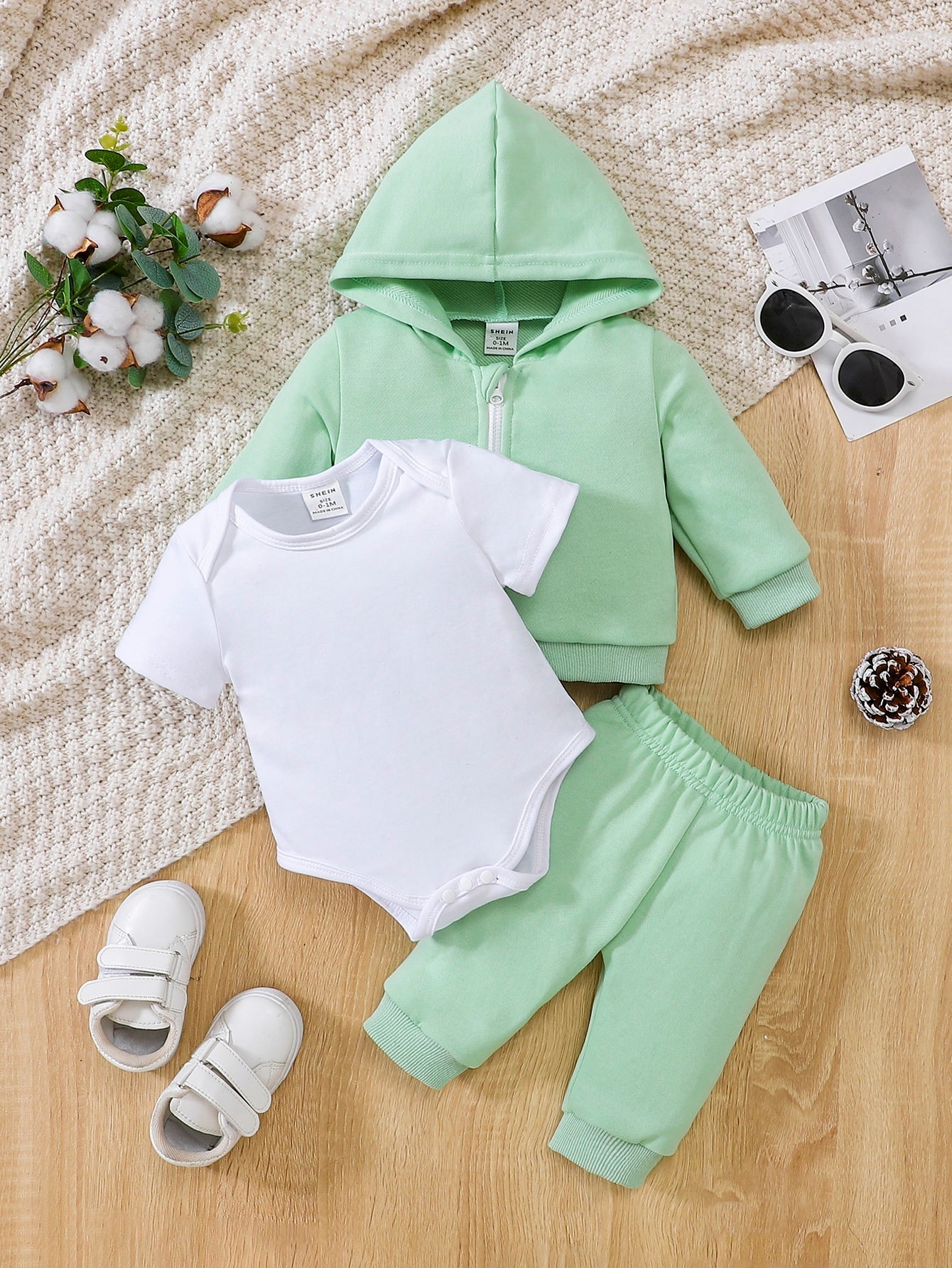 a baby boy's outfit and shoes on a bed