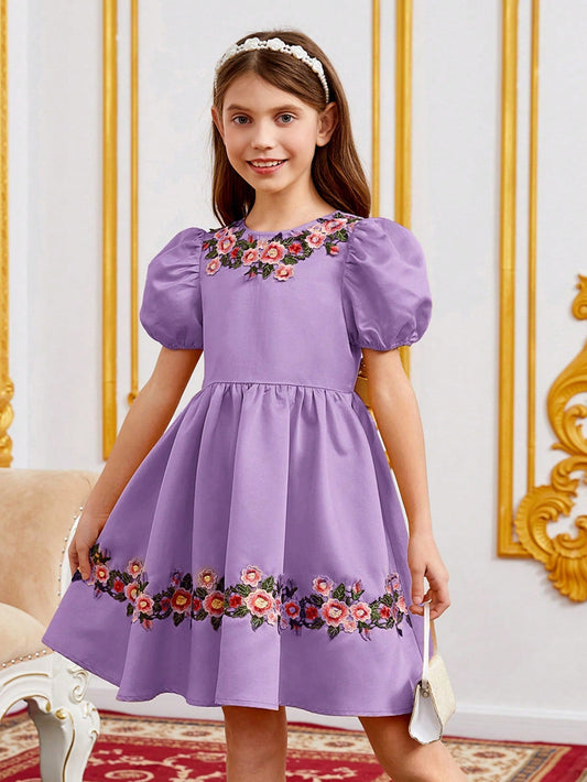 a little girl in a purple dress standing in a room