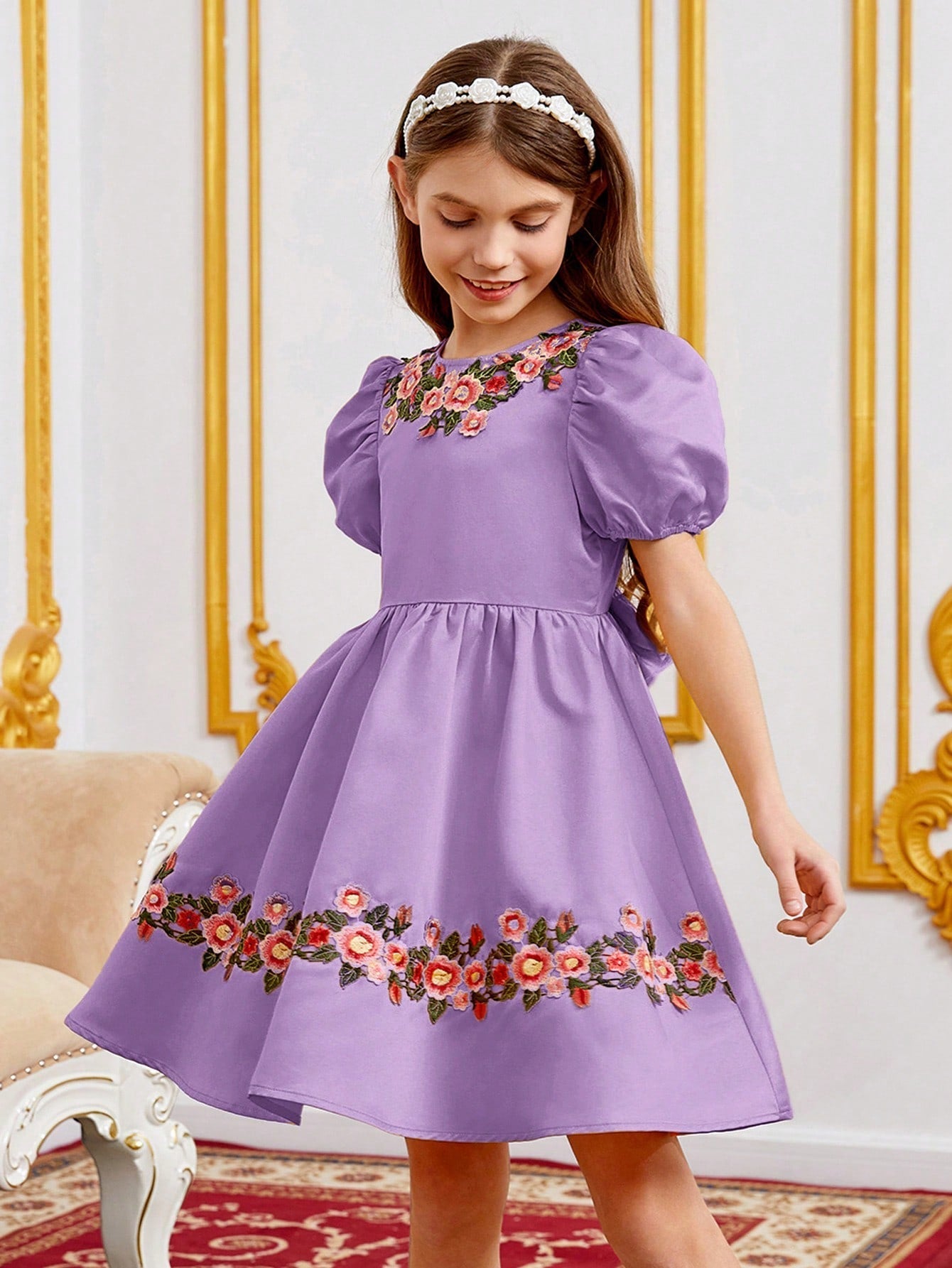 a little girl wearing a purple dress with flowers on it