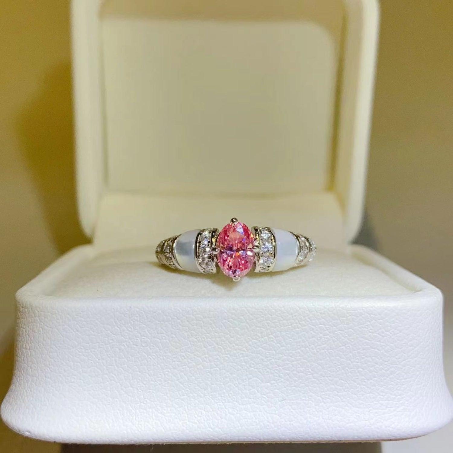 Beautiful pink moissanite and sterling silver ring showcased in an elegant white jewelry box.