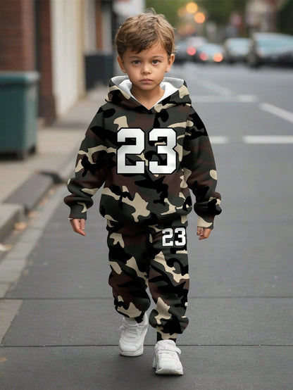 a young boy walking down a street wearing a camo hoodie