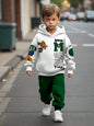 a young boy walking down a street wearing a white hoodie