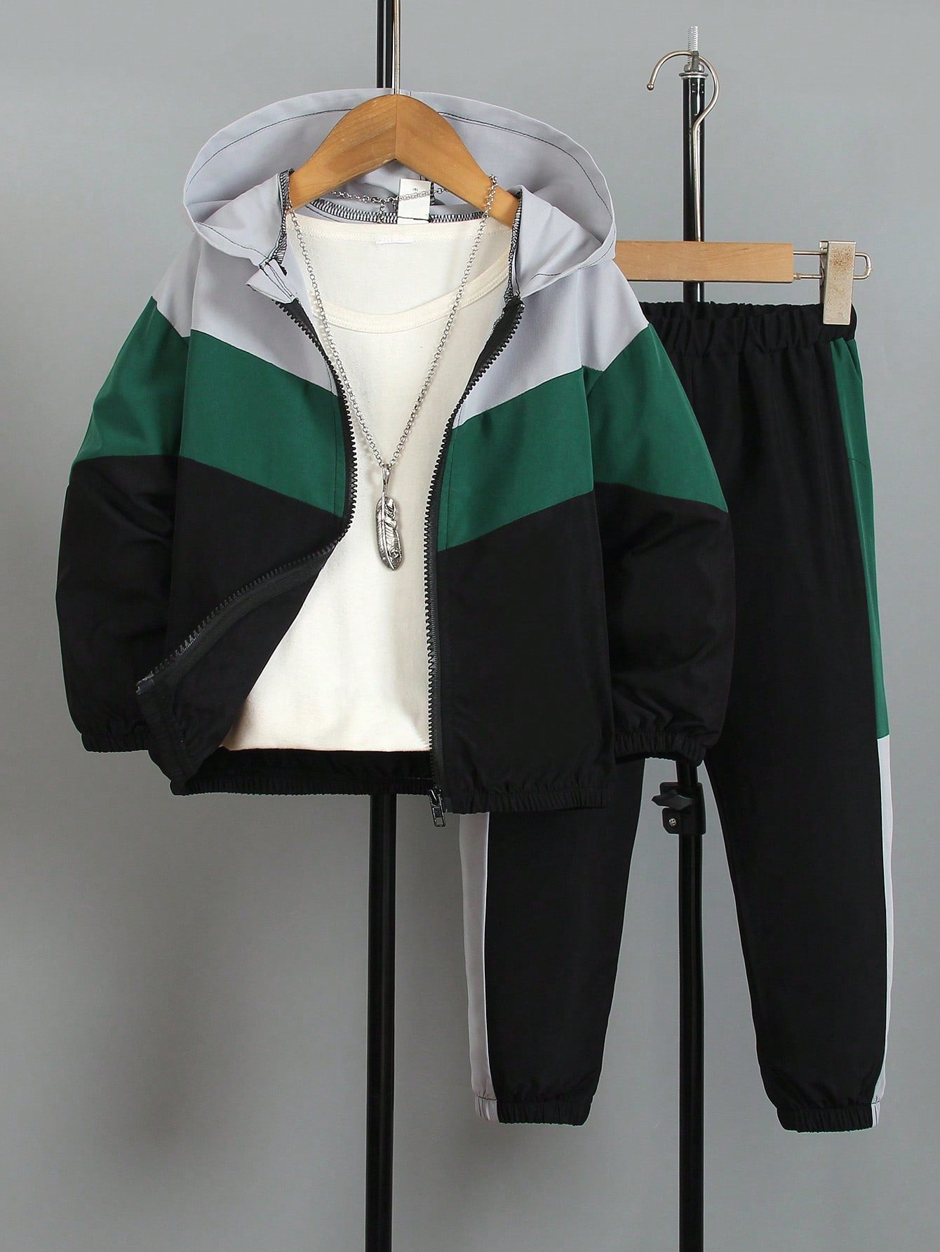 a green and black jacket and pants hanging on a rack