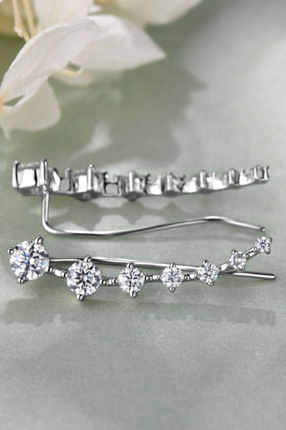 Elegant sterling silver earrings adorned with sparkling moissanite gemstones, showcased against a soft floral background.