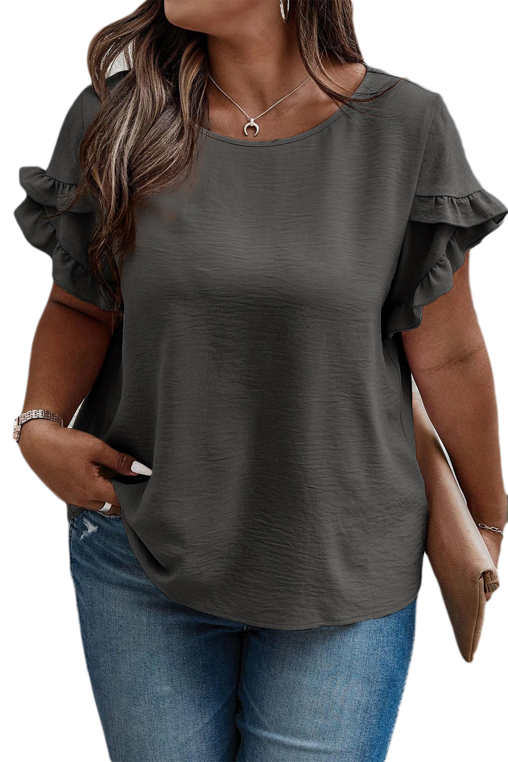 a woman wearing a gray top with ruffled sleeves