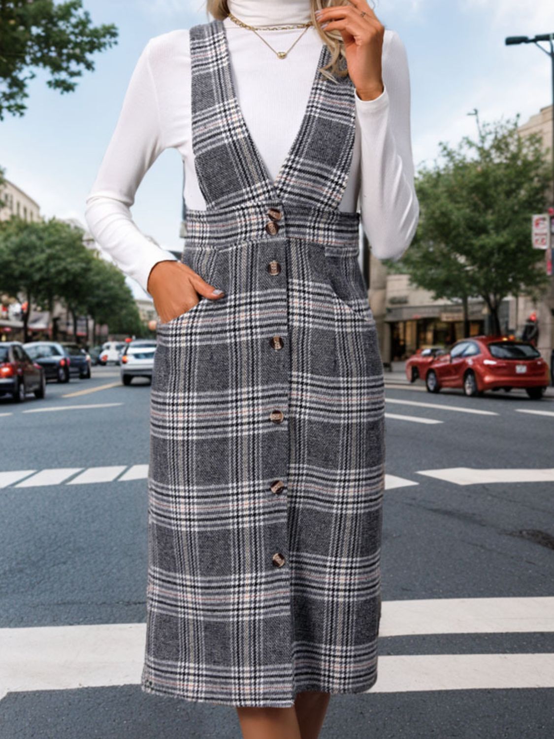 a woman standing on the street wearing a plaid dress