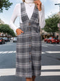 a woman standing on the street wearing a plaid dress