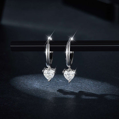 Glamorous heart-shaped diamond earrings on a sleek black background