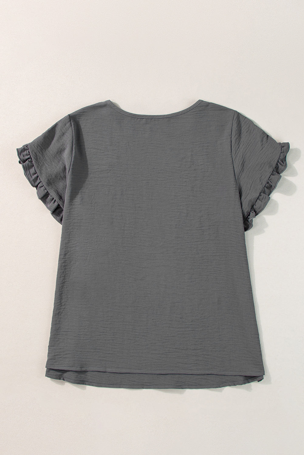 a gray t - shirt with ruffles on the sleeves