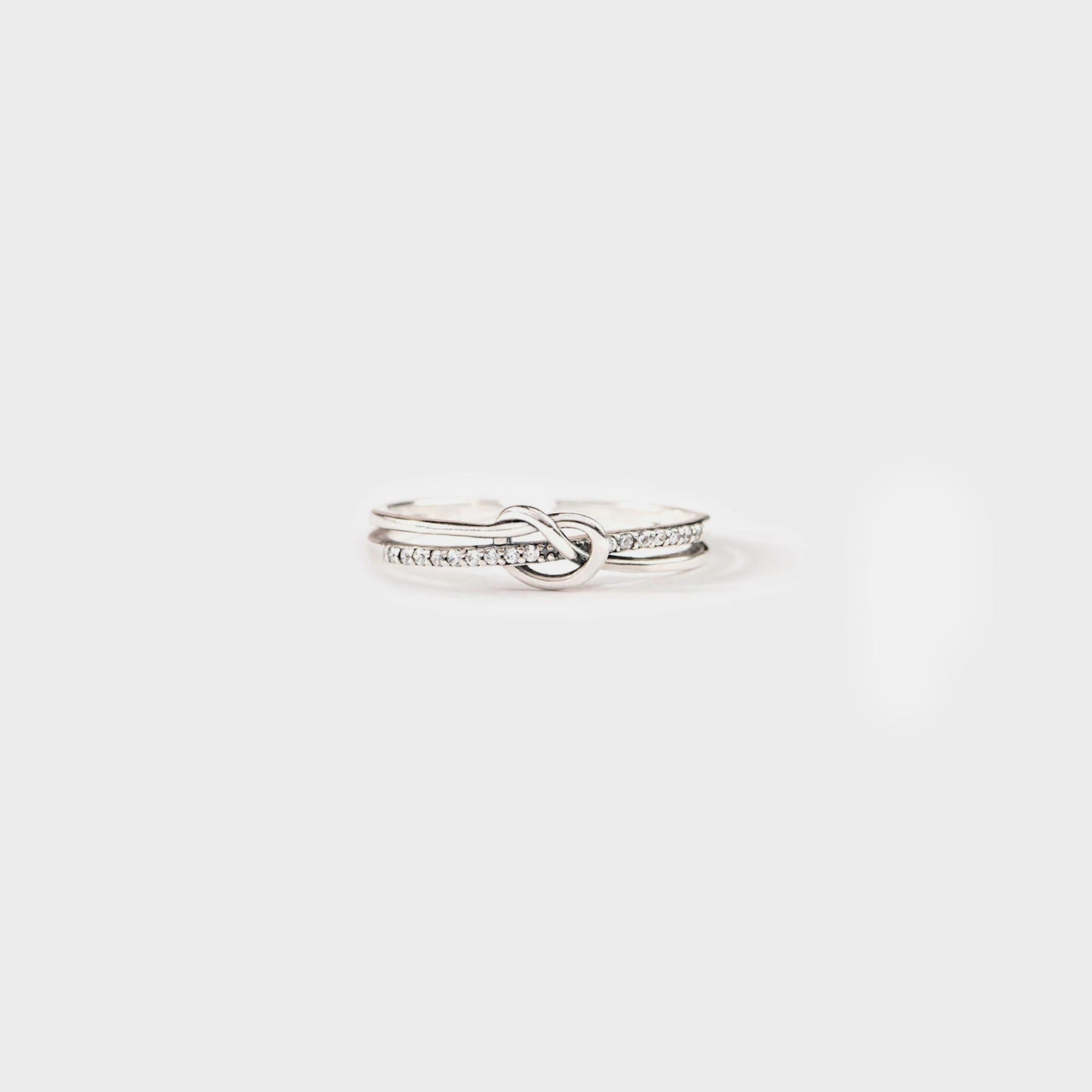 a white gold ring with a knot and diamonds