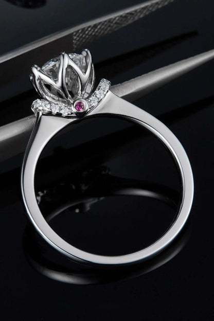 Elegant moissanite stone ring with sterling silver crown design featuring sparkling diamond accents on a dark backdrop.