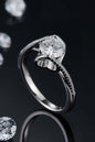 Elegant twisted sterling silver ring with sparkling moissanite center stone surrounded by paved diamonds