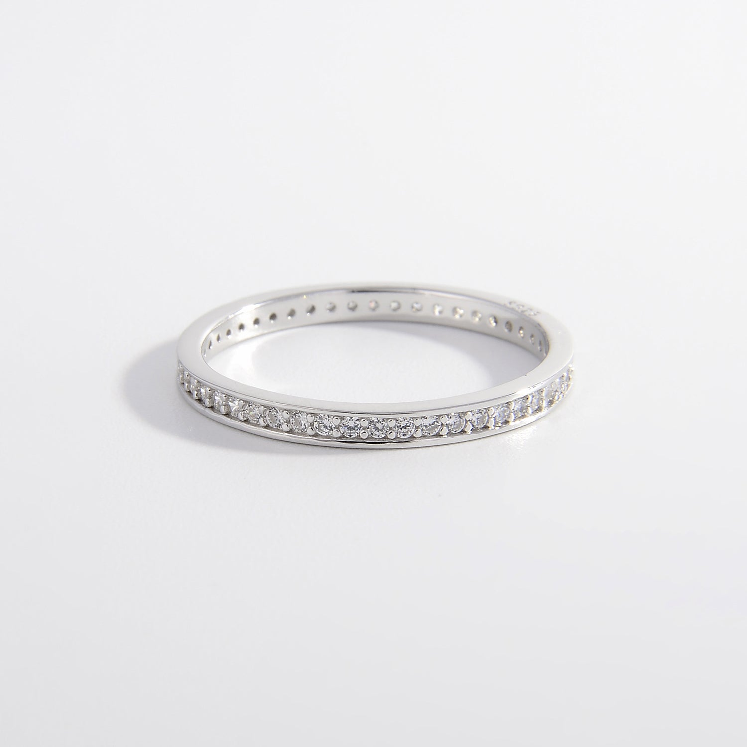 a white gold ring with a row of diamonds