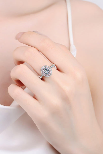 Elegant sterling silver halo ring with shimmering moissanite center stone, showcasing a luxurious yet feminine design.