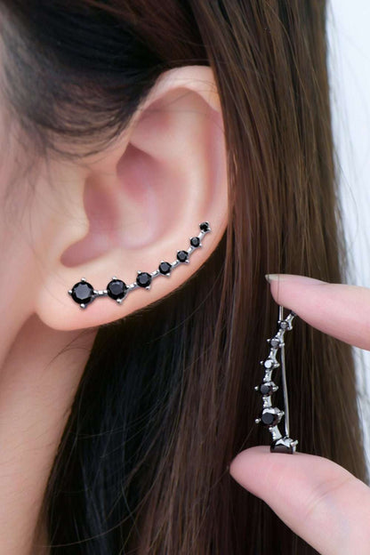 Elegant black crystal stud earrings set against long, dark hair in a close-up product image.