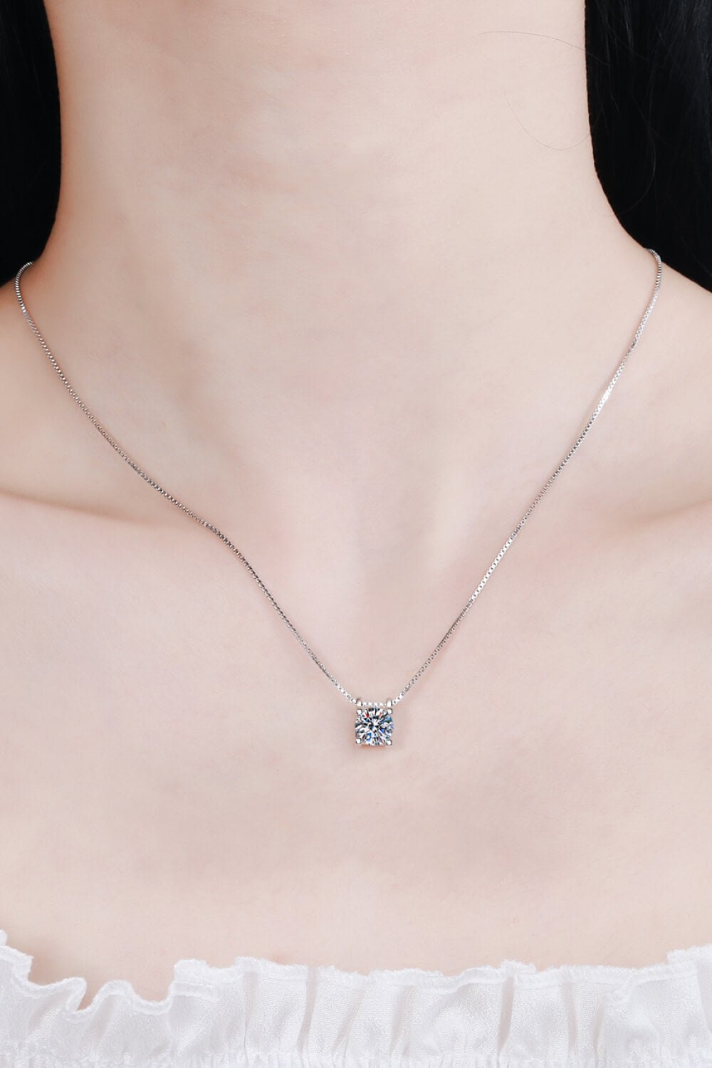 Elegant 1-carat moissanite pendant necklace with sterling silver chain on woman's neck