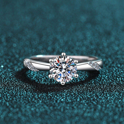 Stunning 1 Carat Moissanite Engagement Ring on a Sparkling Teal Background